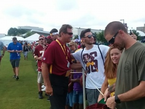 Robert Sipos taking a picture with one of the Redskins all-time great Quarterback, Joe Theismann